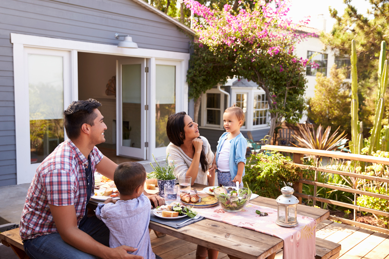 a family eating breakfast at a backyard dining area
